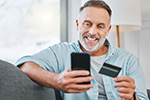 Mann mit Smartphone und Kredikarte