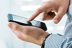 Person tippt auf Mobiltelefon